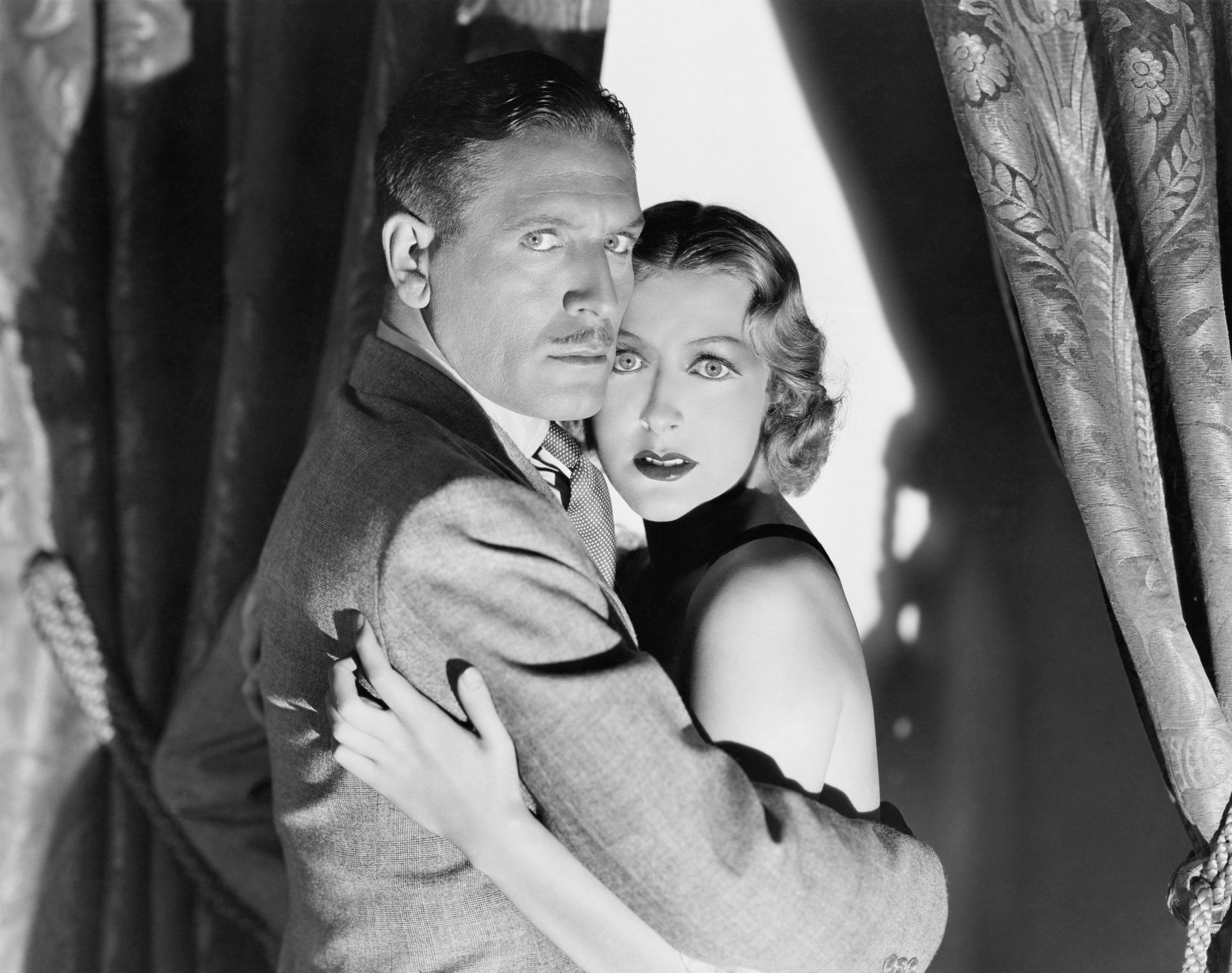 Man and woman looking scared holding each other